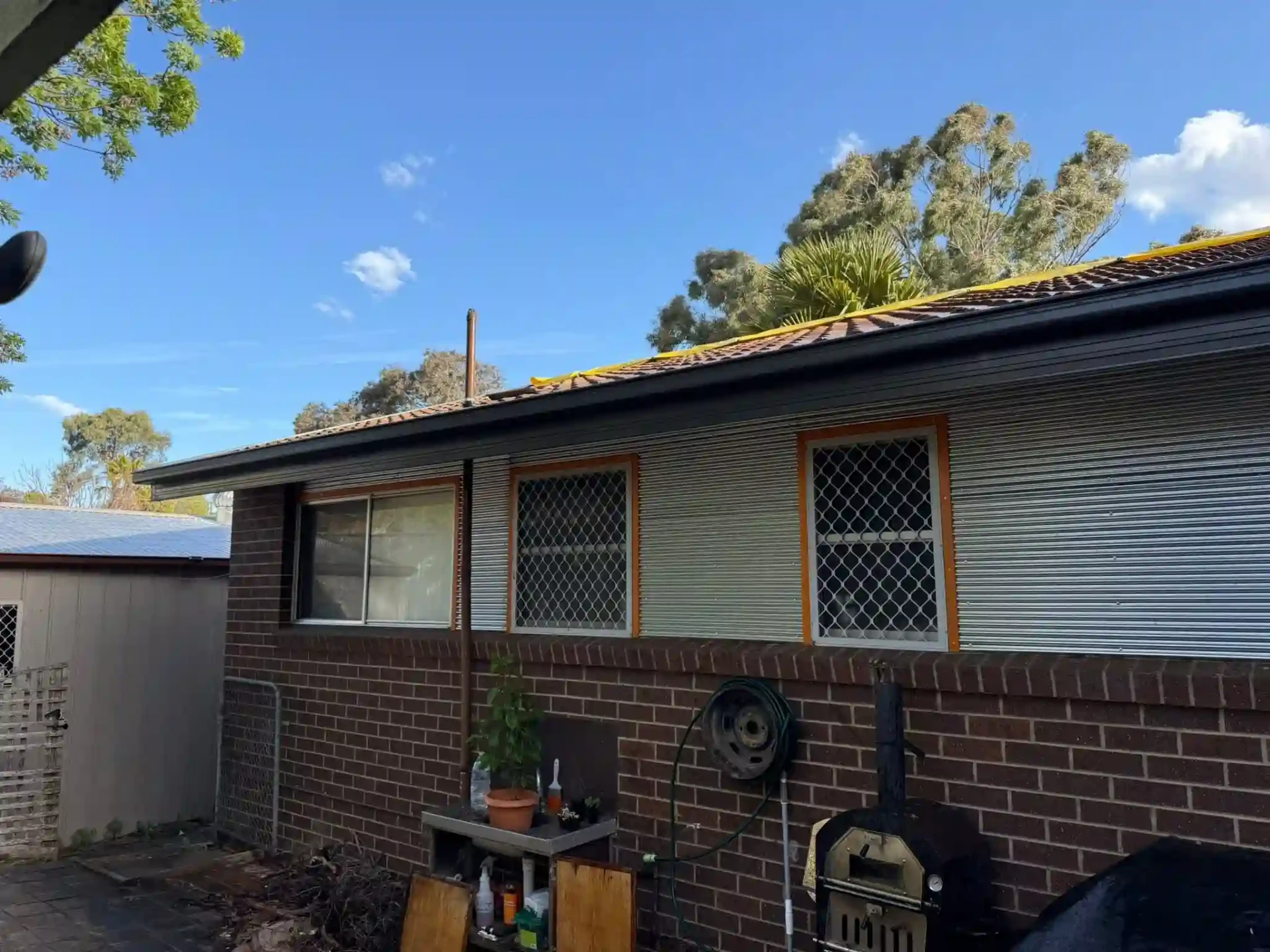 Side of the Queanbeyan home with new dark gutters, roof edging and rear patio