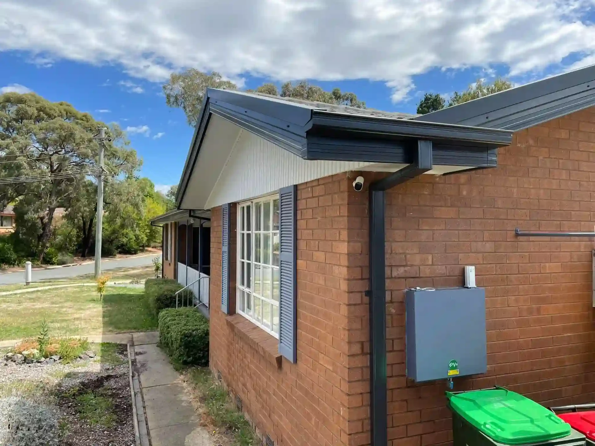 Back garden view of the Duffy home showing restored roofline and paved entertaining area