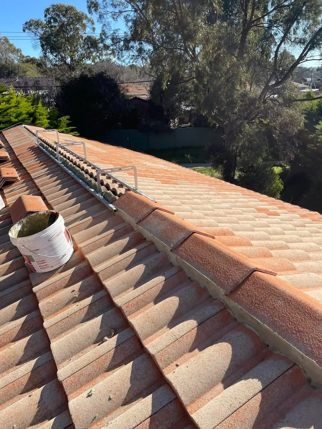 Repointed ridge line with fresh mortar on a Canberra tile roof