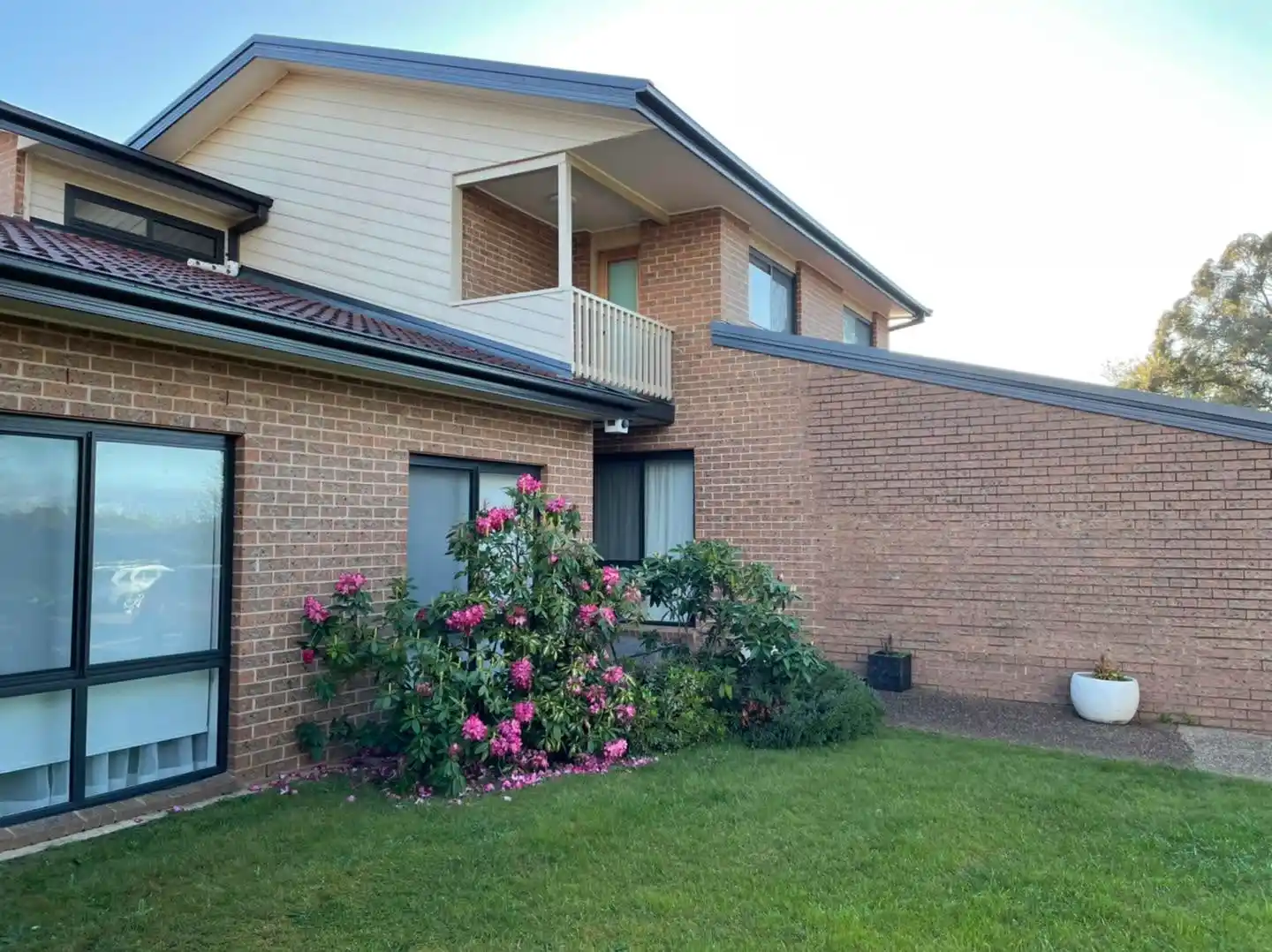 Cream upper-storey and brick lower level of the Canberra home with restored terracotta roof tiles