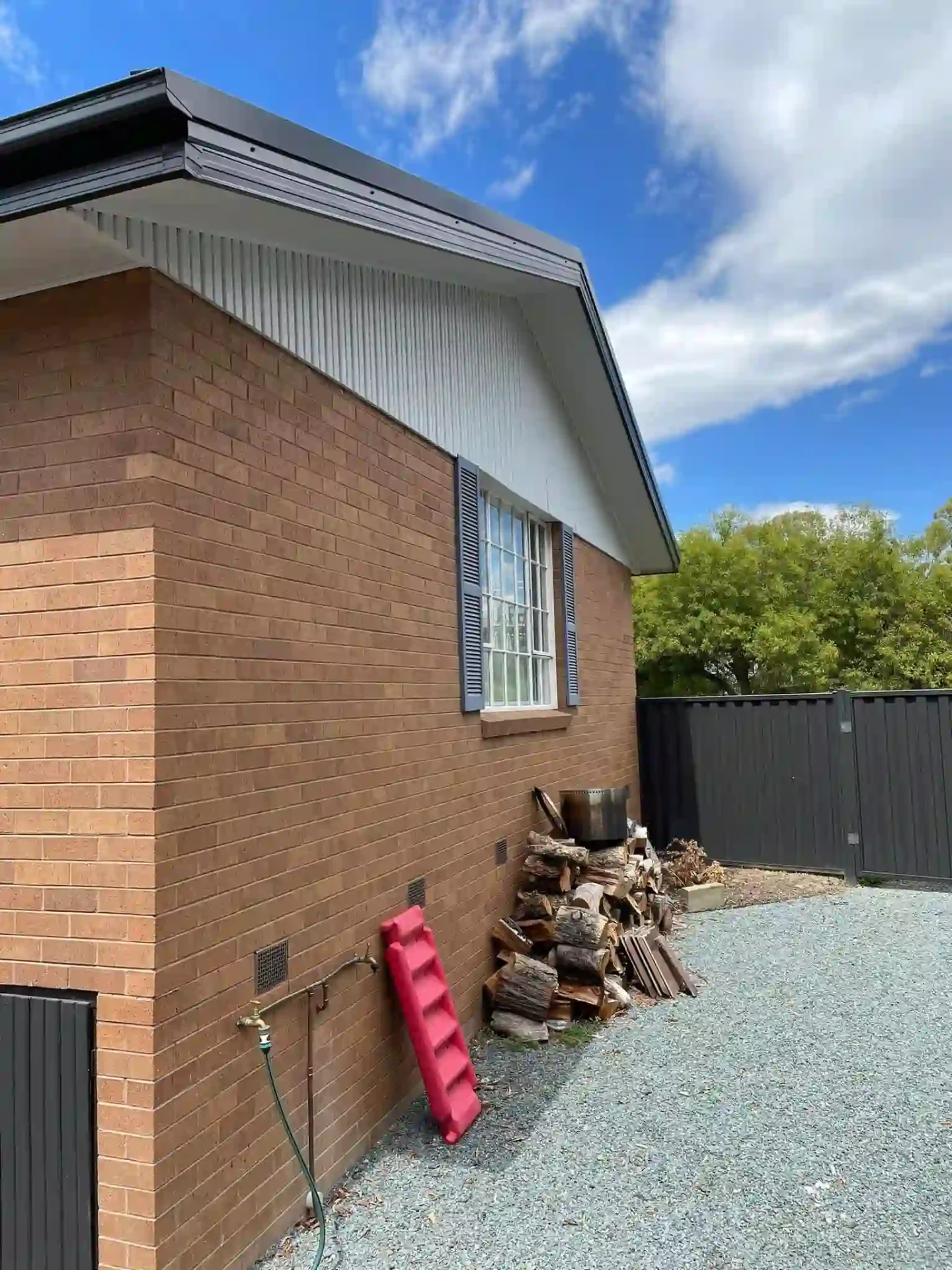 Rear corner of the Duffy home showing restored roof trim and downpipes