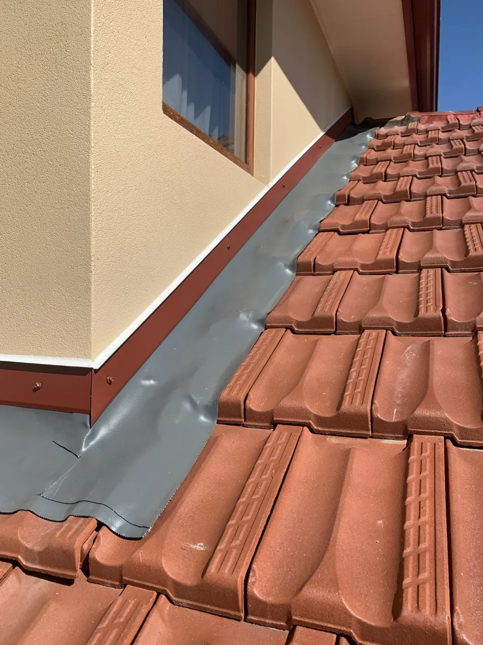 Wakaflex flashing running along a roof valley beside terracotta tiles