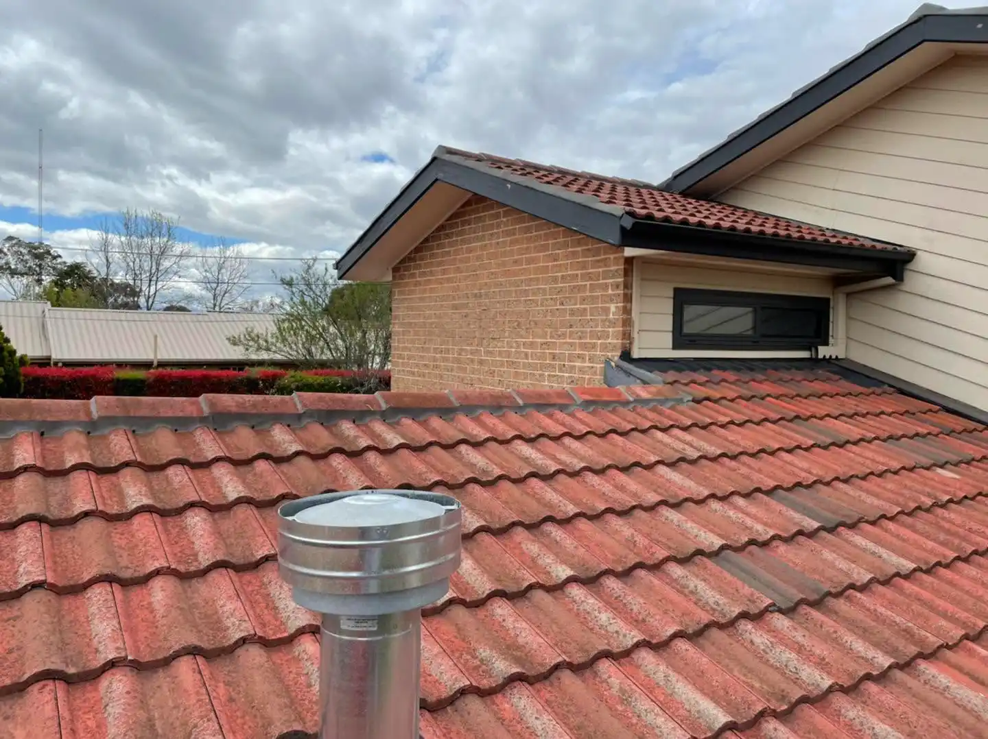Rooftop view with metal flue and restored terracotta tiles on the Canberra home